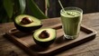 A refreshing avocado shake sits gracefully in a tall, clear glass placed on a rustic wooden tray. The shake is perfectly blended, showcasing a smooth texture with subtle shades of green. Fresh slices 