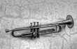 an antique Jazz trumpet on an old wall in black and white