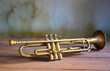 an antique Jazz trumpet on an antique brown wooden table