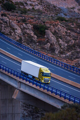 Wall Mural - Truck with refrigerated trailer driving on a viaduct, elevated view.