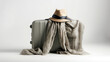 Stylish travel concept with a hat and scarf draped over a suitcase against a plain background.