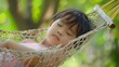 Peaceful Asian Child Napping in Outdoor Hammock Surrounded by Lush Greenery