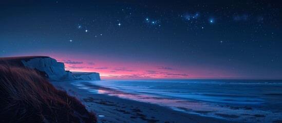 Wall Mural - The coastline stretches out, kissed by the evening tide, as stars begin to emerge in the velvety night sky.