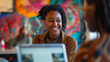 © Maksym - In a collaborative workspace filled with vibrant artwork, a black young woman shares a laugh with a colleague while reviewing a presentation on her laptop, her smile reflecting the