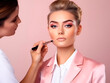 © Alina - A cosmetologist does makeup on a woman's face on a light background