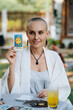 A bald woman tarot reader show a tarot card The sun