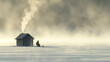 A small wooden cabin sits on a frozen lake. There is smoke coming out of the chimney and a person standing nearby.

