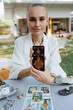 A bald woman tarot reader has a session with a client