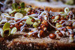 Mixed microgreens with cotyledons and roots on bread. A set of vitamins. Soft selective focus. Artificially created grain for the picture.