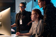© Mediaphotos - Side view portrait of three female creators looking at computer screen together in studio copy space