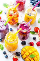 Poster - Multi-colored fruit cocktails in glasses on the table
