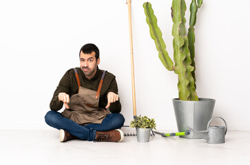 Poster - Gardener man sitting on the floor at indoors showing thumb down with two hands