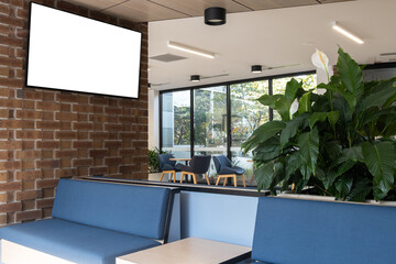 Wall Mural - A mockup background texture of a TV or electronic digital screen mounted on a wall in a public indoor waiting area. A blank white advertisement display or notice board in a hall. Copy space for design
