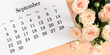 Flat desk paper calendar for September 2024, top view. Pale delicate roses on a beige background.