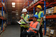 © saltdium - A senior warehouse supervisor with a disability in a wheelchair manages the work with the team, business logistics, and transport concept