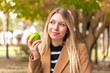 © luismolinero - Young pretty blonde woman with an apple at outdoors