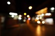 A blurry city street at night with lights from the street lamps and cars