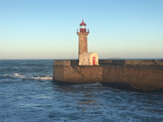 Wall Mural - Felgueiras Lighthouse on the stone pier against the backdrop of a blue sky. Porto, Portugal