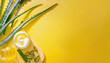 A jar of cream and chopped aloe leaves on a yellow background, neatly stacked side by side, facial care, cosmetologist