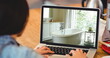 Image of person using laptop with house sitting bathroom displayed on screen