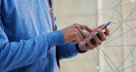 Wall Mural - Image of a web of connections over Caucasian man standing on a street, using smartphone