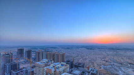 Wall Mural - Cityscape of Ajman from rooftop during sunrise timelapse. United Arab Emirates.