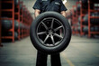 Mechanic holding tire at repair garage or in shop. Replacement of winter or summer tires concept