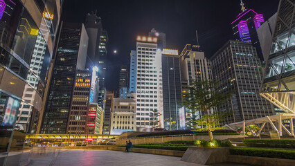 Wall Mural - Night view hyperlapse of modern city in park with fountain and skyscrapers around. Time lapse. Hong Kong