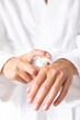 © Wavebreak Media - A young Caucasian woman applying lotion to her hands at home
