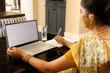 © Wavebreak Media - Indian young woman working on laptop at home, taking notes, copy space