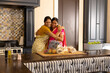 © Wavebreak Media - Indian mother and teenage daughter, hugging at home in kitchen