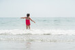 Girl in Pink Bathing Suit Splashing in Ocean Waves in Maine