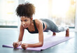 Black woman, gym and plank for wellness on mat, core exercise and health club for body or strong abdomen. Balance, sportswear and muscles for fitness or training, serious athlete in pilates workout