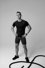 Athletic man with fit muscular body training in studio