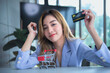 Portrait images, Asian business woman attractive and young sitting on a white table, and mockup credit card in a shopping cart, to business people and shopping online concept.