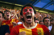 A soccer fan adorned with red and yellow face paint cheering enthusiastically at a football stadium.