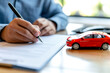 Man buying or selling new or used car. Person signing car insurance document or lease paper close up