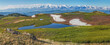 Mountain landscape, small lake, snow on slopes and glaciers, panoramic view