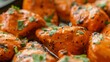 A close-up of tender chicken pieces marinating in a rich and creamy tikka masala sauce, ready to be grilled to perfection.