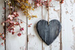 blank heart shaped slate board with space for text hanging on a rustic wooden wall surrounded by flowers