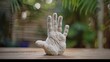 A molded clay handprint created using a homemade moldmaking tool made from a plastic container and molding material..