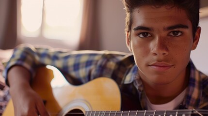 The close up picture of the hispanic male child playing or practicing guitar inside his own room, the guitar practice require music theory knowledge, regular practice and understanding rhythm. AIG43.