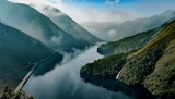 Fototapeta  - Serene lake reflecting a clear blue sky and surrounded by lush green hills and mountains cove