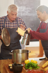 Poster - Senior man, friends and cooking with pot for cheese or diary dish in kitchen together at old age home. Male person or team learning in hospitality with mixing ingredients, apron or recipe at house