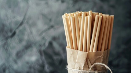 A bundle of biodegradable paper straws wrapped in a paper sleeve and labeled Say no to plastic straws yes to sustainable packaging..