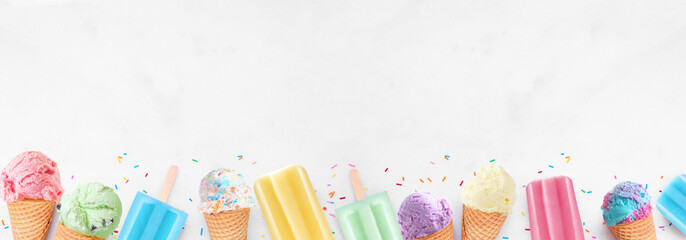 Leinwandbilder - Assortment of colorful pastel ice cream cones and popsicle summer frozen desserts. Top view bottom border on a white marble banner background. Copy space.