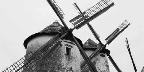 A black and white photo of three windmills. Suitable for historical or agricultural concepts