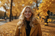 Portrait of a smiling blonde girl in an autumn park on a sunny day.