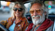© Nano Photos - A smiling man and woman wearing sunglasses sitting in a car, exuding a carefree and joyful vibe.