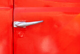 Fototapeta Dmuchawce - Door handle of a retro car close-up. metal lock, door painted red